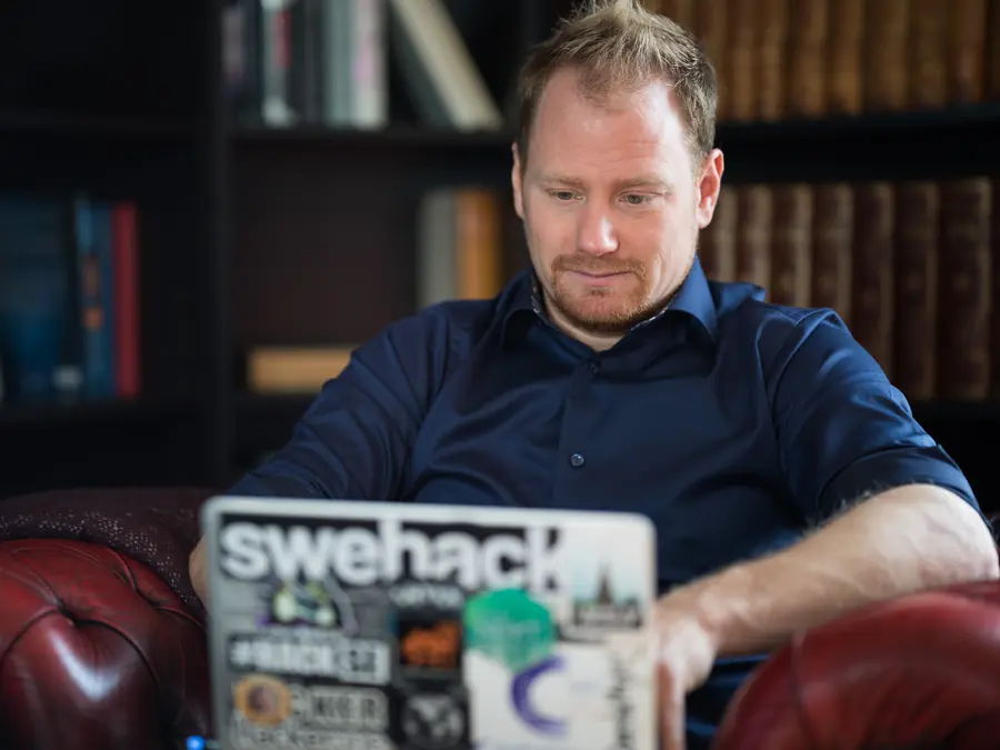 Press photo 05 of David Jacoby: Working on a sticker-covered laptop, library